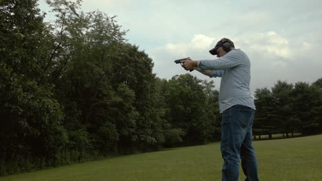 un hombre dispara una pistola mientras la cámara avanza