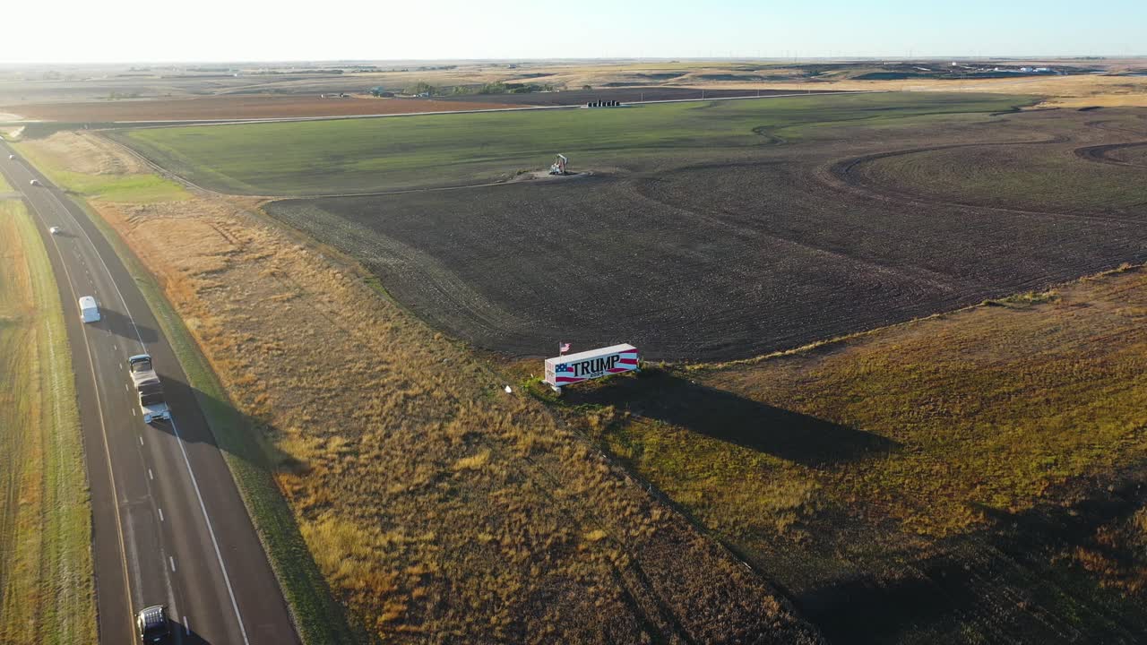 gran cartel de la campaña de donald trump 2024 en el medio oeste rural de kansas exhibido a lo largo de la interestatal i-70 este y oeste pintado en un camión grande en un remolque, tierras agrícolas y campo abierto, vuelo de dronve aéreo