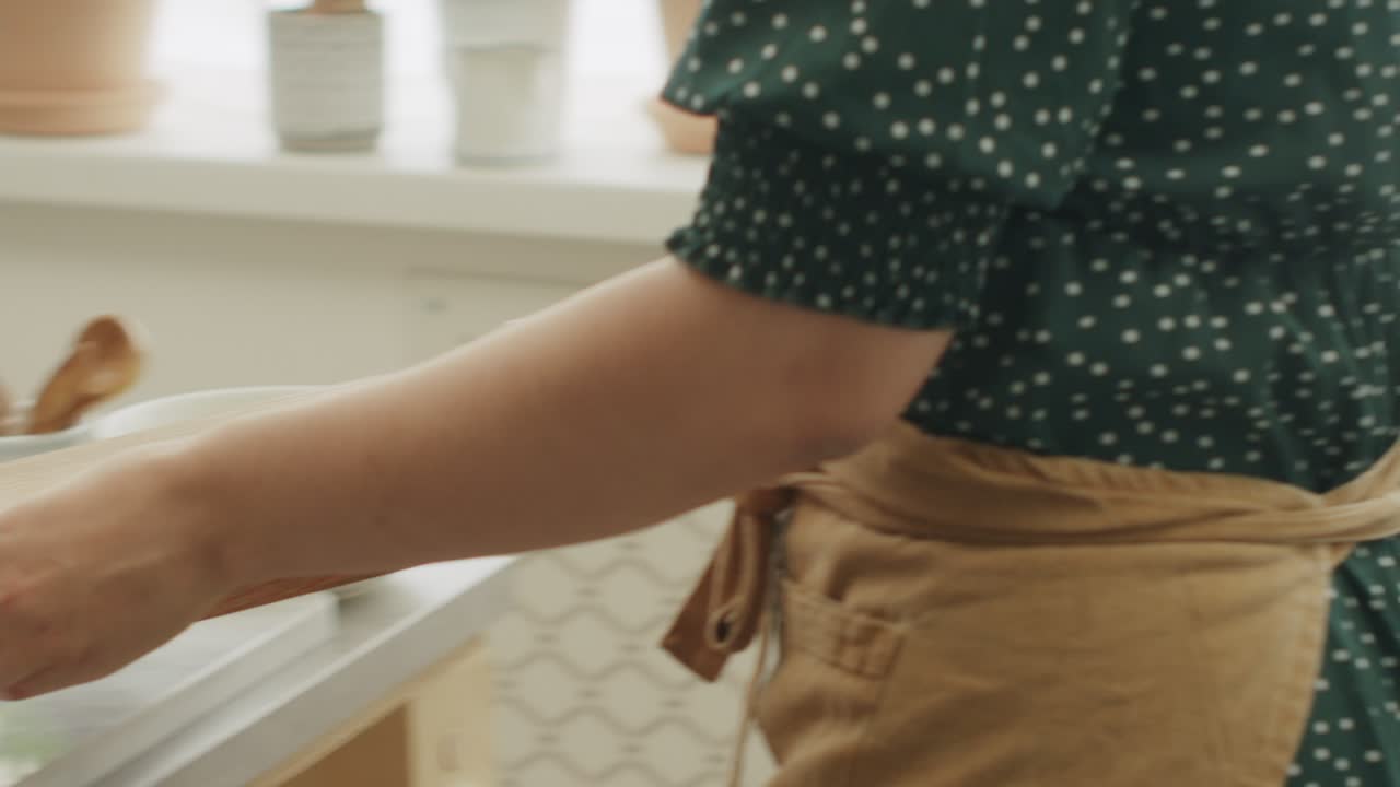 식사 준비 중 테이블 위에  ⁇ 기 보드를 들고 있는 인식할 수 없는 주부