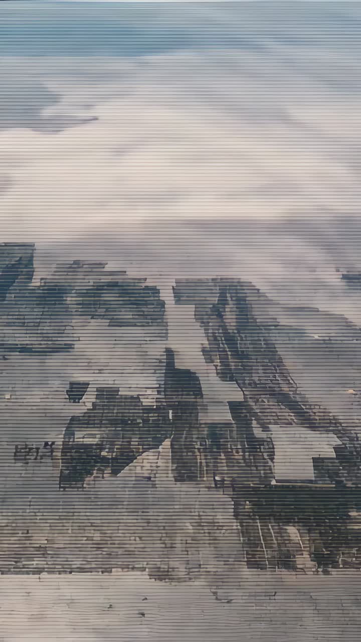 Vertical video: Gliding plane showing sea fog moving in over coastal patchwork fields and canals