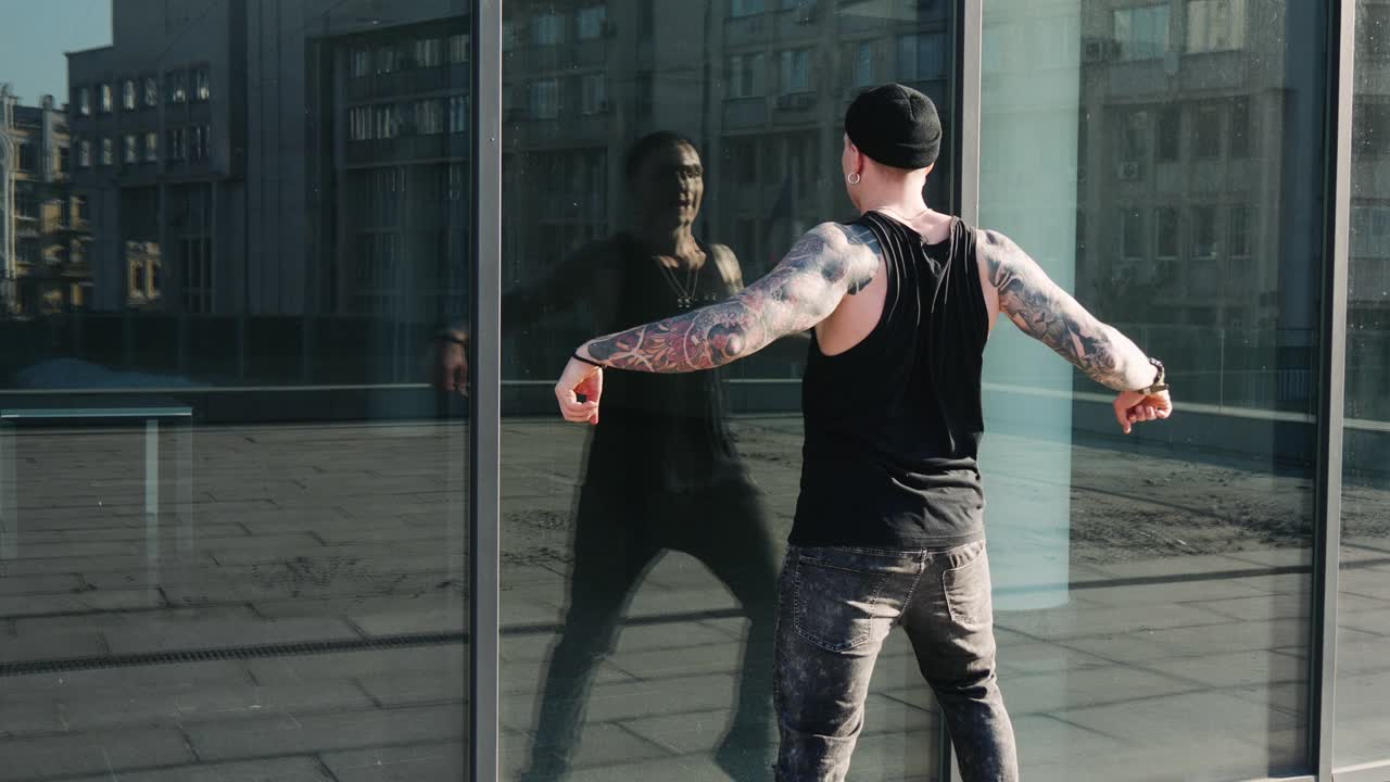 Contemporary hip hop street dancer hipster man with tattoo funky urban dancing freestyle in the city