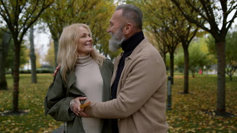 Close-up-romantic-couple-standing-in-autumn-park-in-daytime.-Happy-lovers.