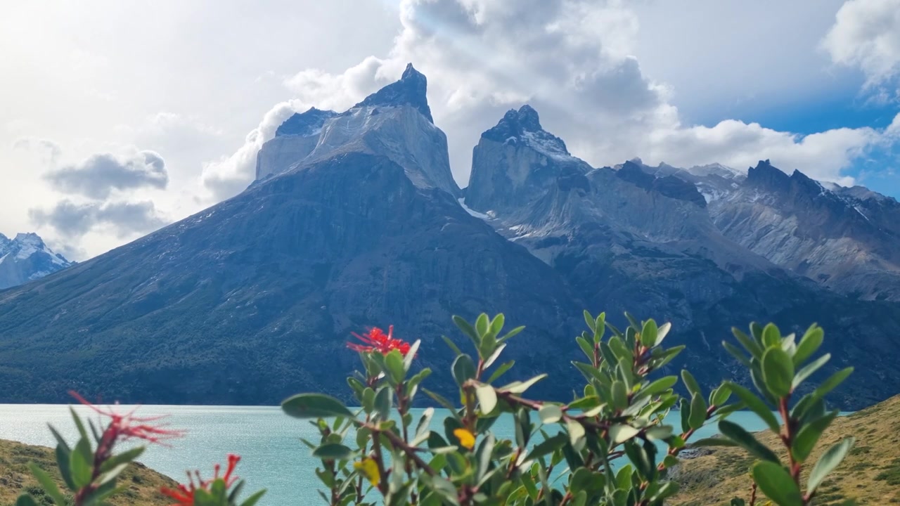 Vue panoramique du lac Nordenskjöld et des emblématiques Cuernos del Paine dans le parc national Torres del Paine, Chili. Des nuages spectaculaires s'amoncellent au-dessus des sommets escarpés, mettant en valeur la nature sauvage et immaculée de la Patagonie.