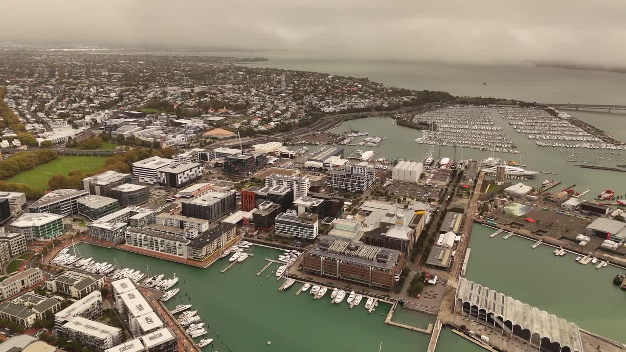 Viaduct Harbour of Auckland city, Wynyard Quarter, and Westhaven Marina, buildings, numerous boats, cloudy sky, New Zealand. Aerial drone panoramic view