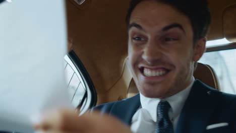 surprised male professional enjoying with good statistics in modern car.
