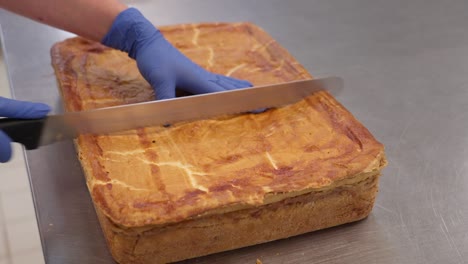 large flódni tray being sliced with a knife