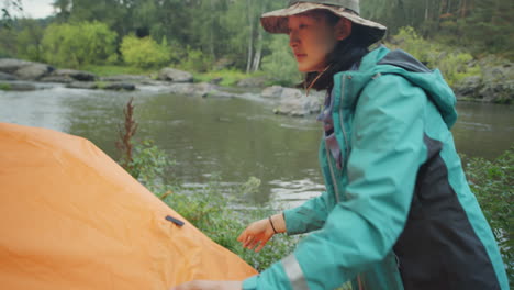 asian woman setting up tent for camping