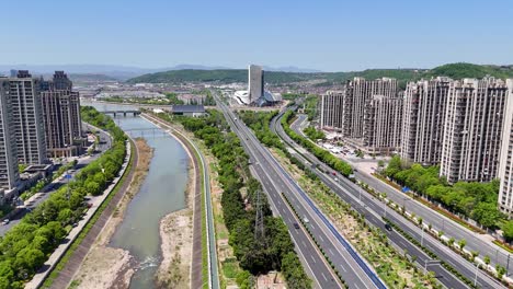 aerial: shaoxing cityscape during the day with high-rise buildings and qiantang river in northeastern zhejiang province, china, push in drone shot