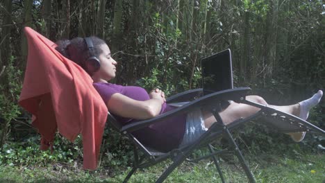 woman in homeoffice is relaxing in the garden instead of working