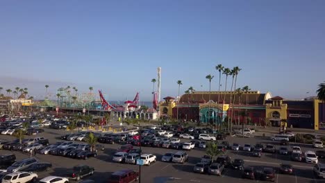 Fun-Park-rides-fall-tower-at-the-beach-Wonderful-aerial-view-flight-panorama-overview-drone-footage-at-parking-area-of-Santa-Cruz-Beach-Boardwalk-USA-2018