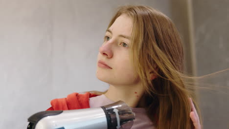 una mujer secándose el cabello.