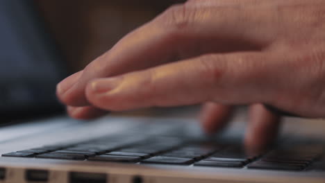 fingers furiously type on laptop keyboard, slow pan close-up