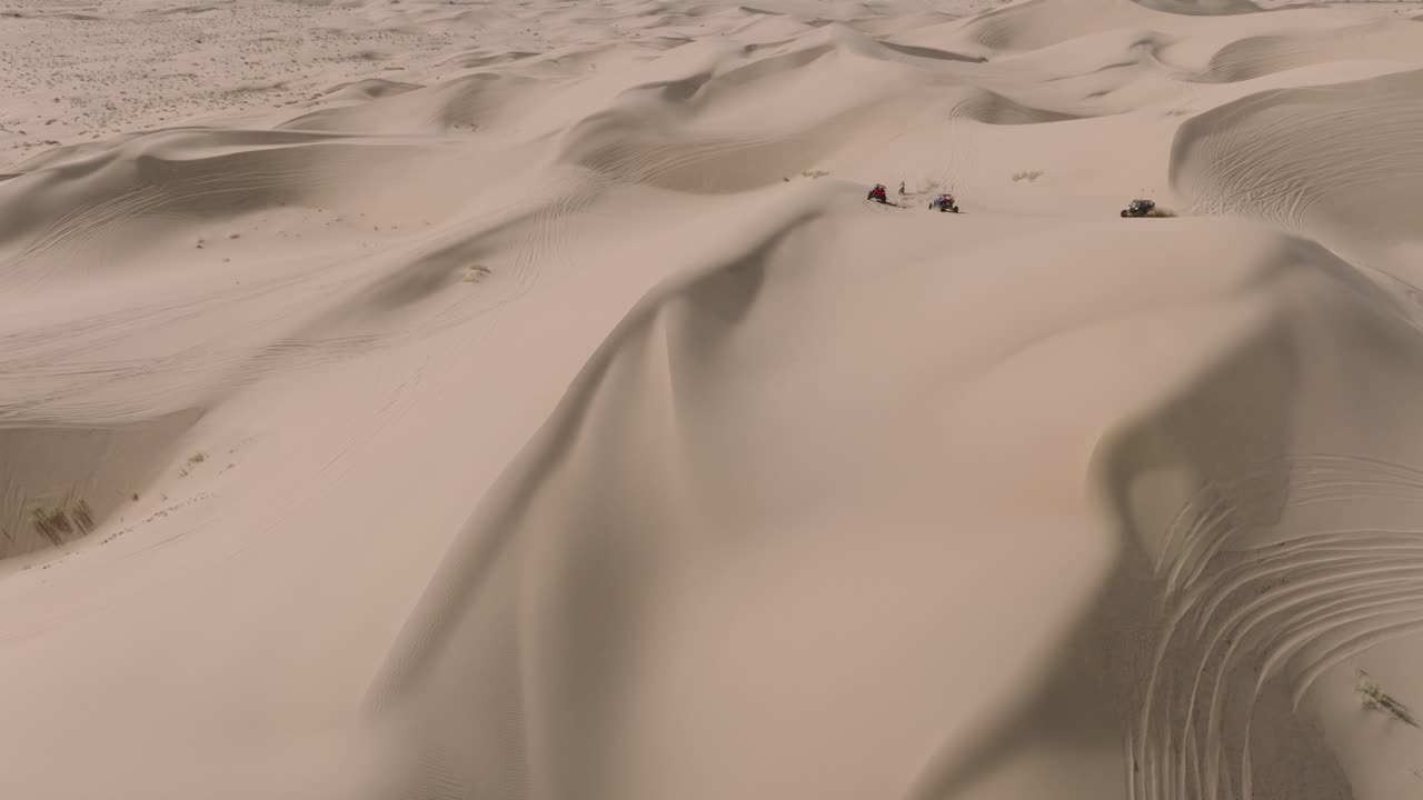 toma aérea de drones de buggies de dunas de arena atv conduciendo en el desierto de california