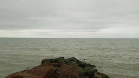 Toma-Del-Mar-Comenzando-En-Una-Barrera-Rocosa-Y-Luego-Moviéndose-Sobre-El-Mar