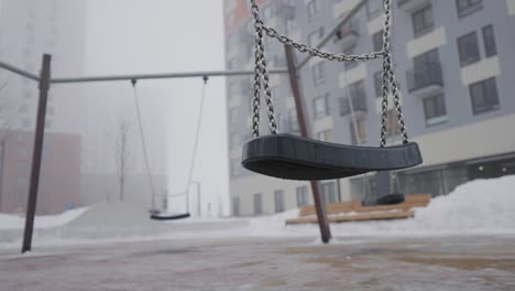 empty swing set in a snowy park