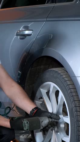 mechanic working on a car wheel in a garage