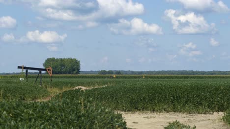 Ölheber,-Die-Sowohl-Arbeiten-Als-Auch-Stationär-Sind,-Verstreut-über-Das-Ackerland-Im-Mittleren-Westen-Von-Illinois