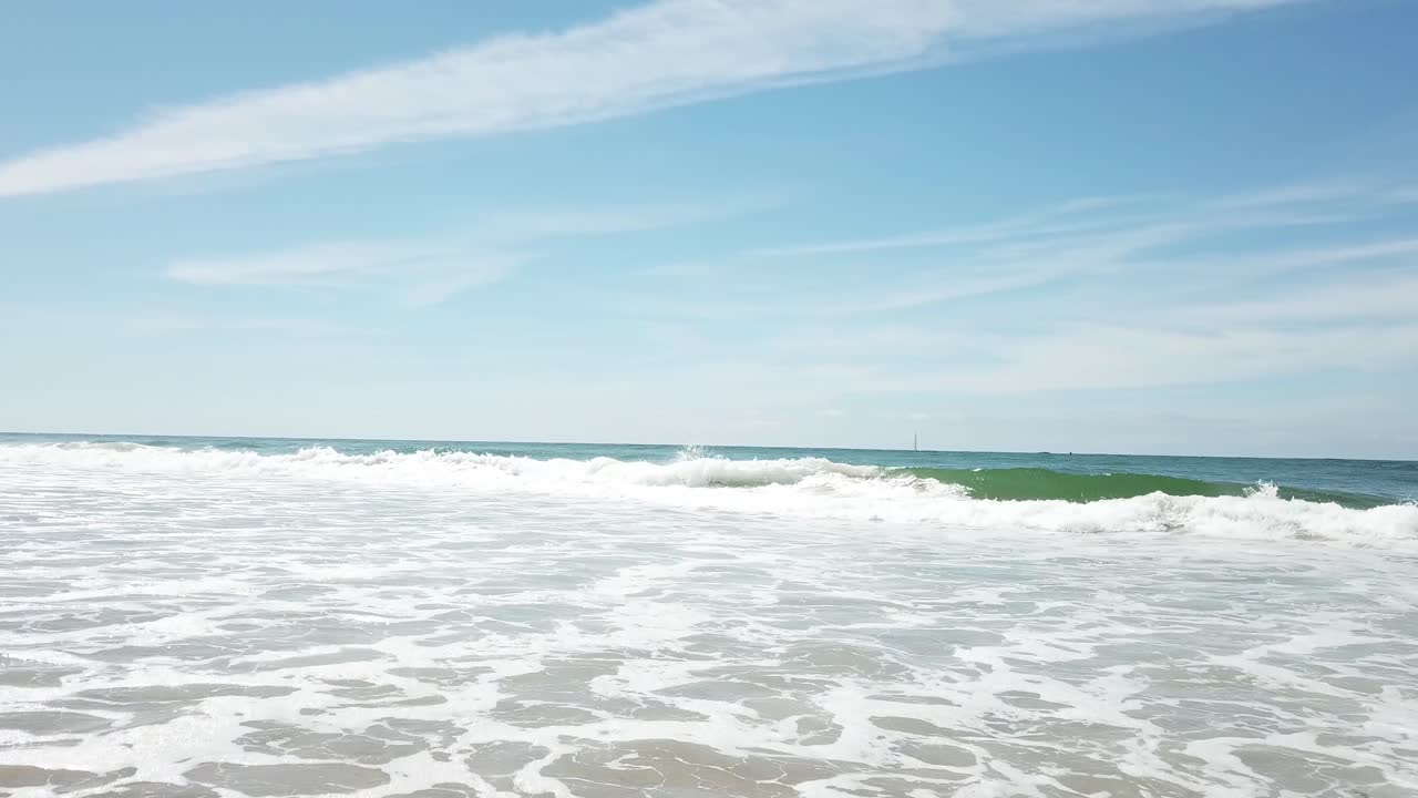 모래 위의 파도의 드론 회전 샷