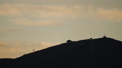 silhouette of a ski mountain and chairlift at sunset