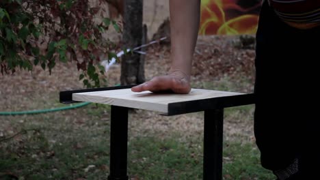 woman preparing to break her first wooden board. board breaks in two