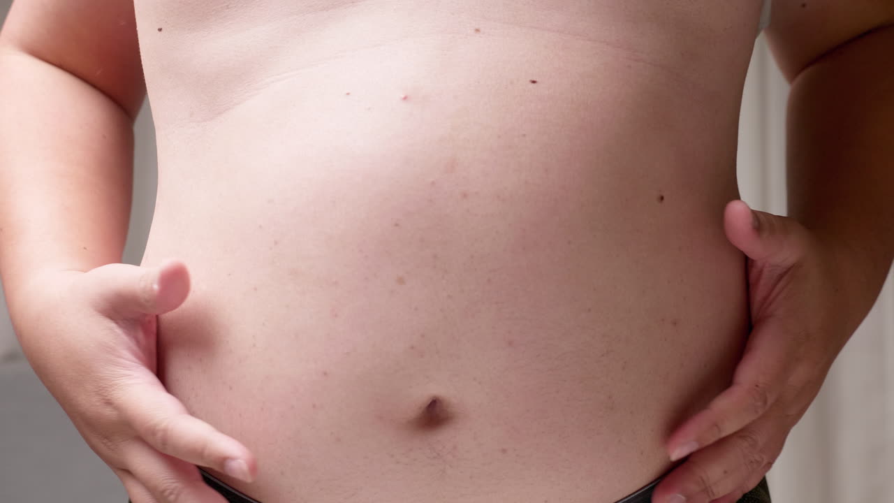 hombre gordo con un gran vientre hombre mano sosteniendo excesiva grasa del vientre, concepto de sobrepeso