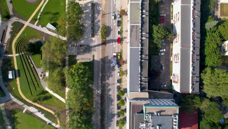 Tracking-Car-Traffic-on-Road-Near-Park-Centralny-on-Summer-day,-Gdynia,-Poland---High-Top-Down-FLyover