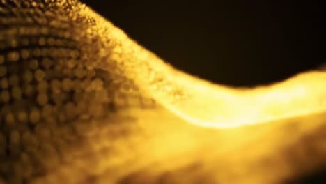 golden waves dance gracefully against a dark backdrop, creating stunning visual patterns. the elegant movement and texture evoke a sense of beauty and tranquility, captivating the viewer's attention.