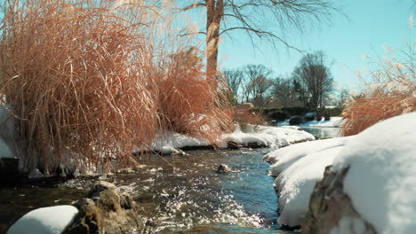 Slow-pan-right-shot-of-winter-river-emptying-into-lake