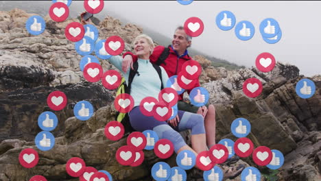 animation of digital love and like icons over senior couple in nature taking selfie with smartphone