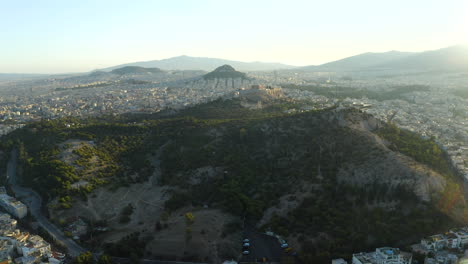 Toma-Aérea-De-Drones-Volando-Sobre-El-Parque-De-Atenas-Volando-Hacia-La-Acrópolis-Y-El-Centro-De-La-Ciudad,-Grecia