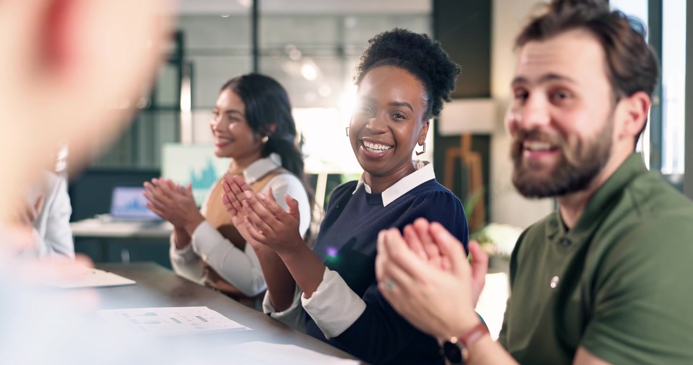 Team aziendale diversificato che applaude durante una riunione in ufficio