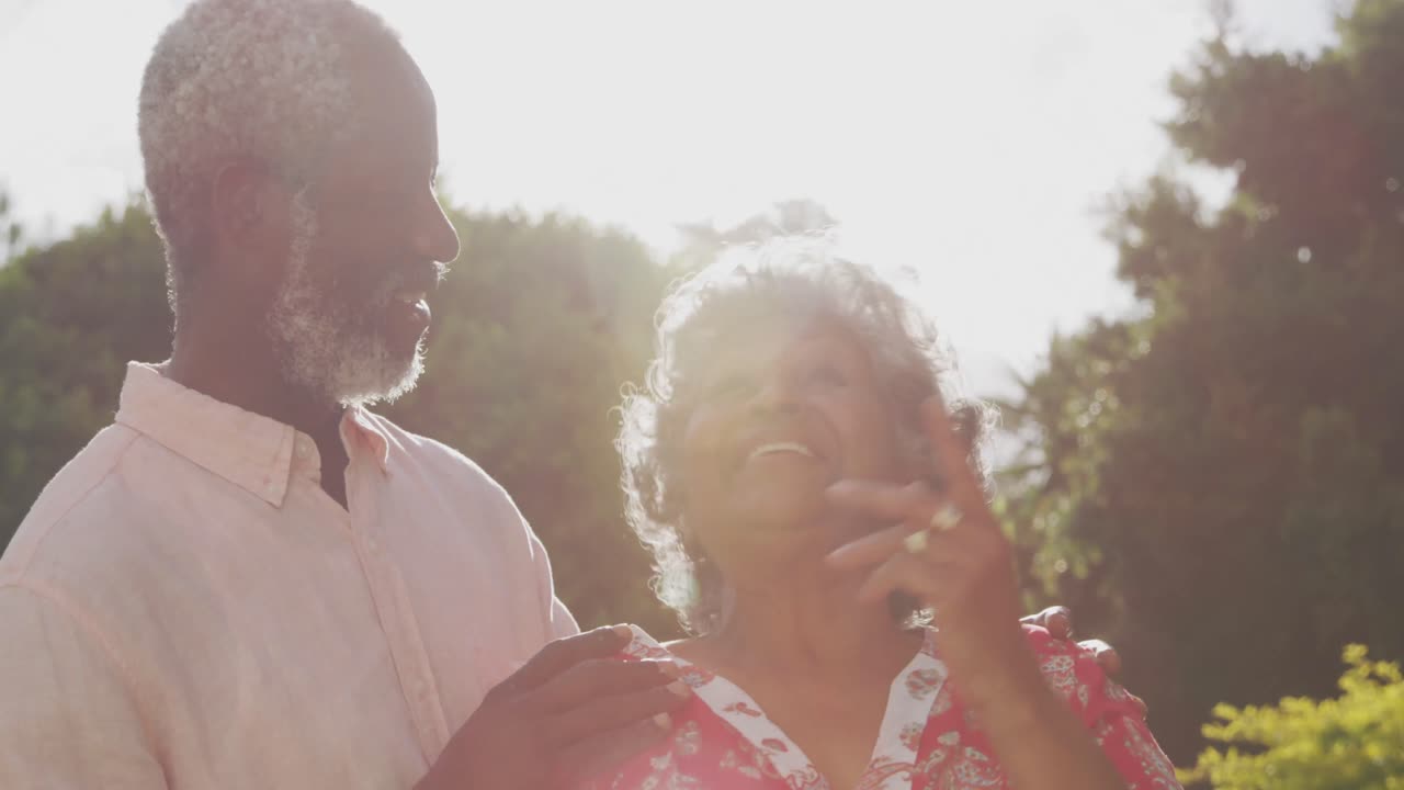 노인 아프리카계 미국인 부부가 정원에서 함께 시간을 보내고 있습니다.