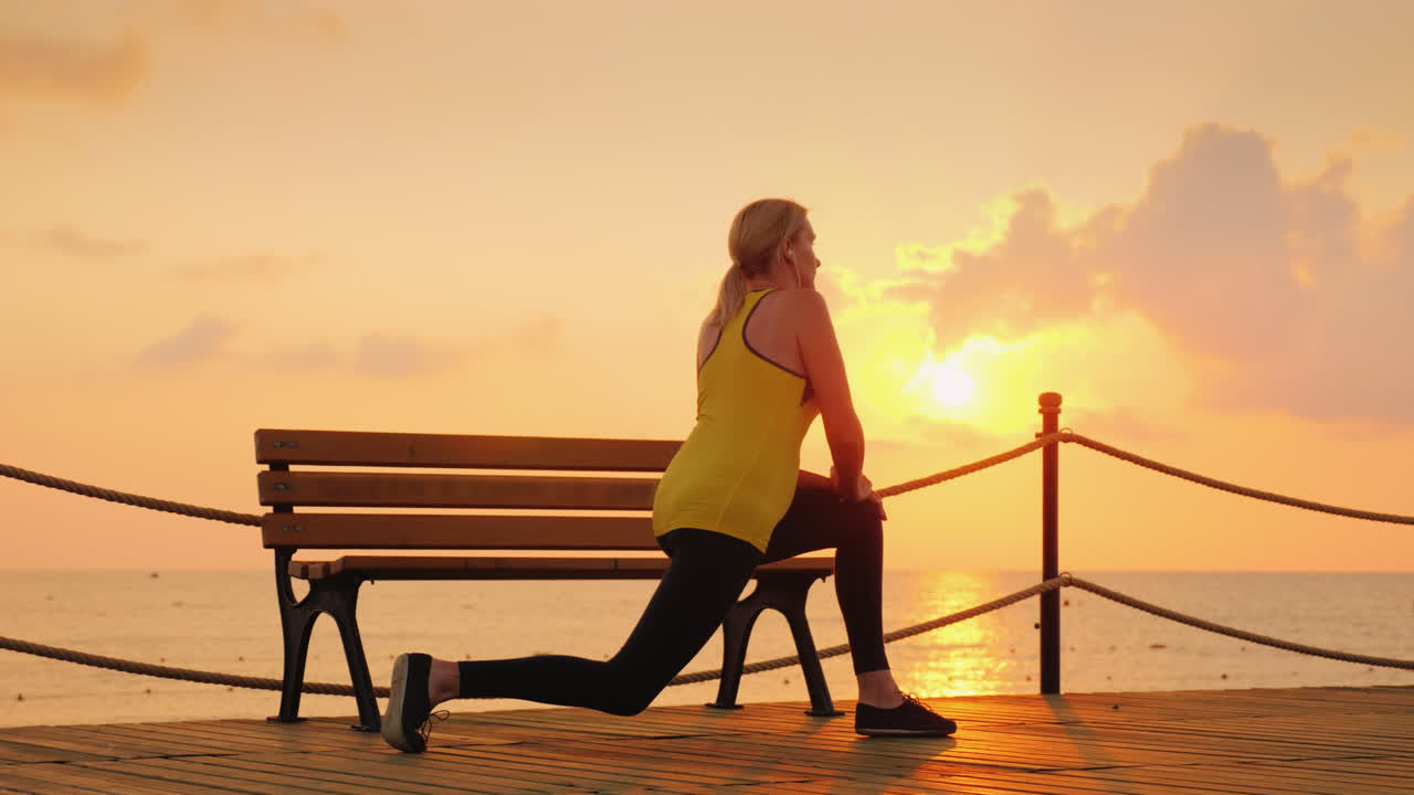 un joven atleta hace un calentamiento matutino en el muelle marino de una mañana fresca en el contexto de
