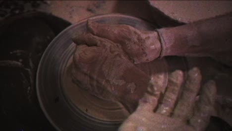 a potter teaches a woman to make clay dishes. a man takes a woman's hands. vintage effect.