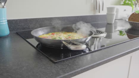 panning shot of omelet cooking in a skillet with extraction system