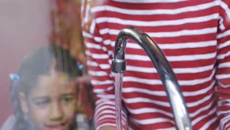 Mother-and-daughter-washing-dishes-in-kitchen-4k