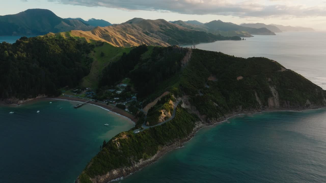 뉴질랜드 남쪽 섬 아오테아로아의 마를보로 사운드 (marlborough sounds) 에 있는 외 테 아우미티 (te aumiti) 프랑스 패스 (french pass) 에 있는 조화로운 보호된 만, 집과 정박한 배의 공중 풍경.