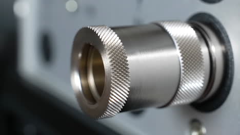 close-up of hand adjusting knurled metal connector