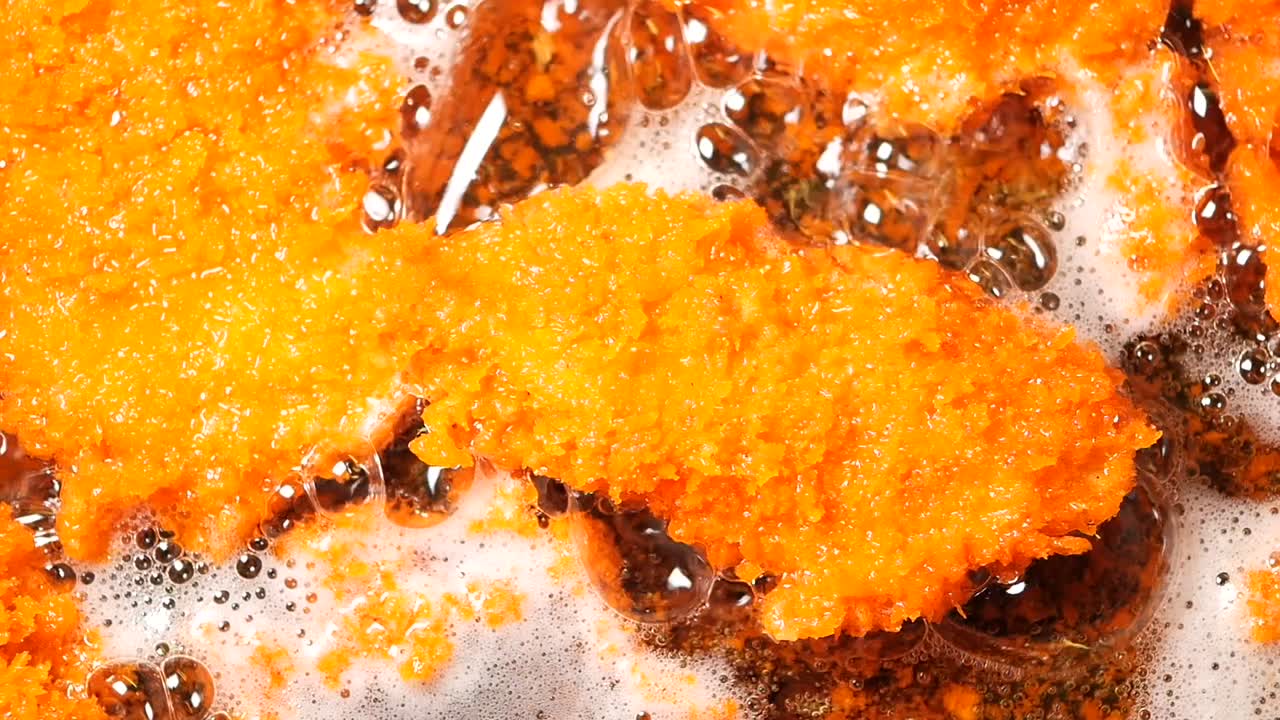 Breaded Chicken Pieces Frying in Oil