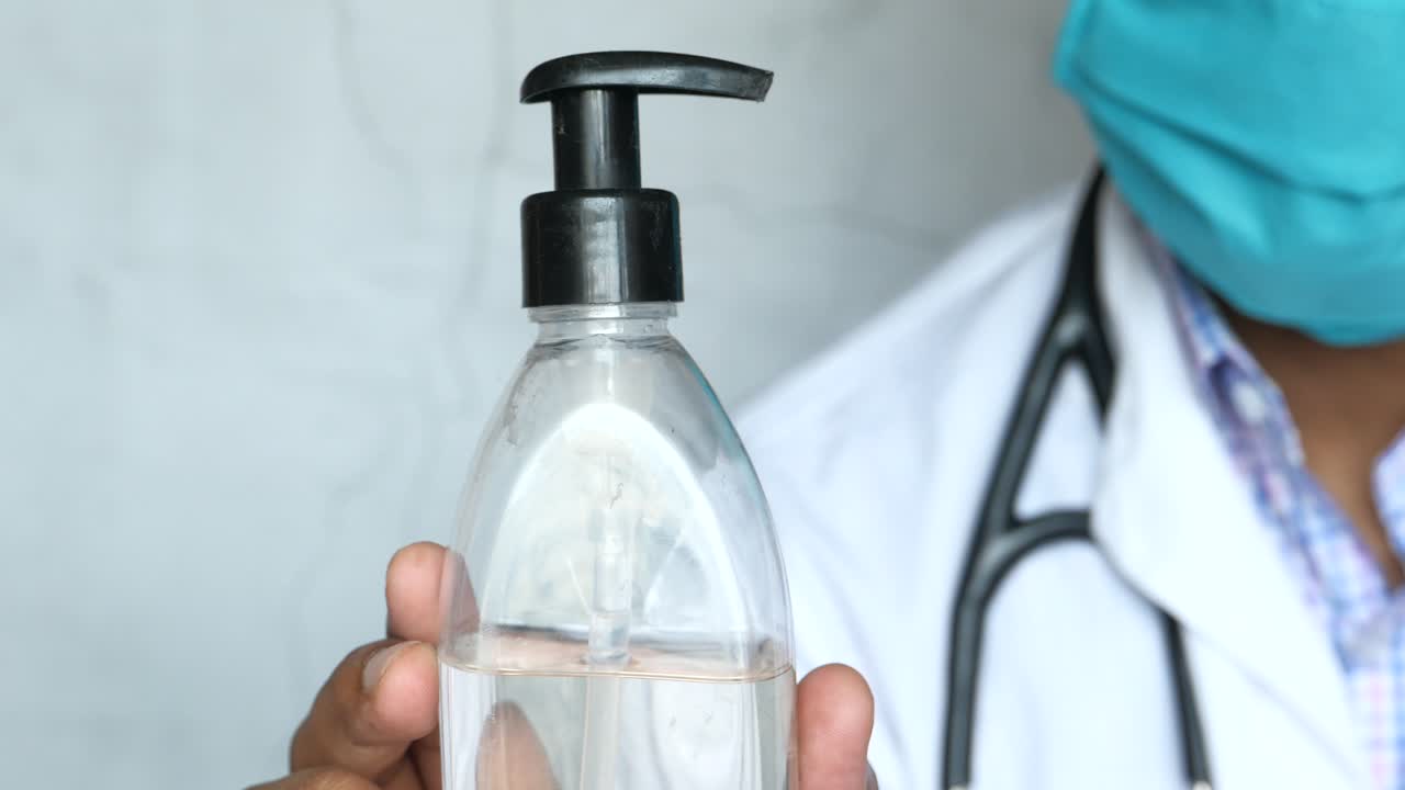 médico con desinfectante para las manos