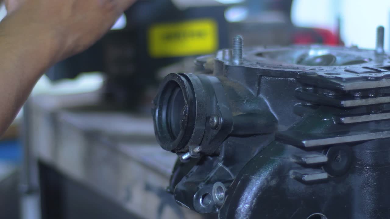 Engine block under maintenance, mechanic's hands background