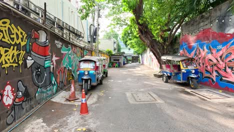 colorful graffiti and tuk-tuks in bangkok alley