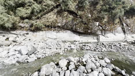 Ein-Zerklüftetes-Flussbett-Mit-Verstreuten-Felsbrocken-Und-Fließendem-Wasser