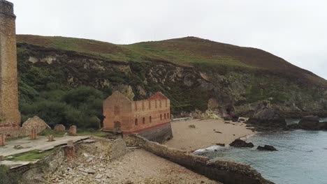 Porth-Wen-aerial-establishing-view-abandoned-Victorian-industrial-brickwork-factory-remains-on-Anglesey-eroded-coastline