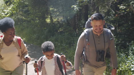 una alegre familia multiétnica caminando juntos en las vacaciones de verano