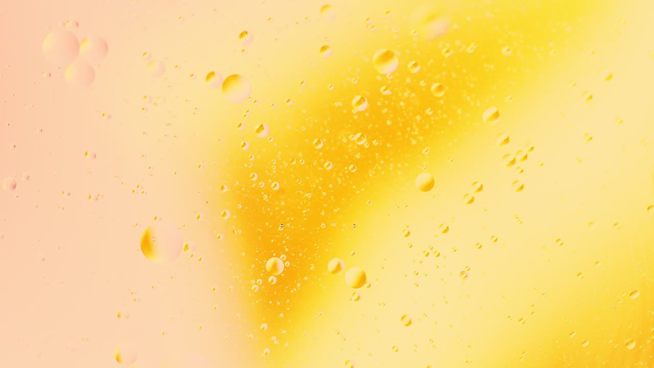 Primo piano ravvicinato di bolle d'olio in rotazione nell'acqua con sfondo astratto di miscelazione a gradiente di colore