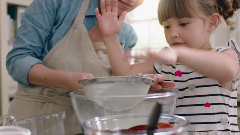 Glückliches-Kleines-Mädchen-Hilft-Mutter-Beim-Backen-In-Der-Küche,-Mischt-Zutaten,-Sieben-Mehl-Mit-Einem-Sieb-Und-Bereitet-Zu-Hause-Ein-Rezept-Für-Cupcakes-Vor