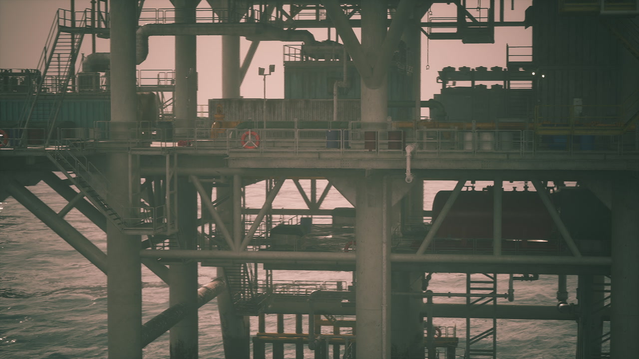 Oil rig structure in the ocean during a cloudy sunset