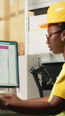 vertical video black female with hi vis vest registering awb tracking info with scanner