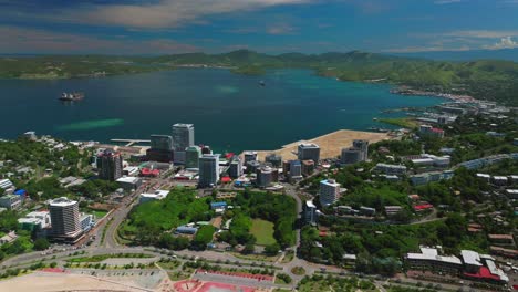 Beautiful-sunny-blue-sky-morning-Ela-Beach-Port-Moresby-Harbour-Marina-Papua-New-Guinea-aerial-drone-car-traffic-PNG-Crown-Hotel-Plaza-Hilton-Walter-Bay-Coral-Sea-capital-city-backwards-pan-up